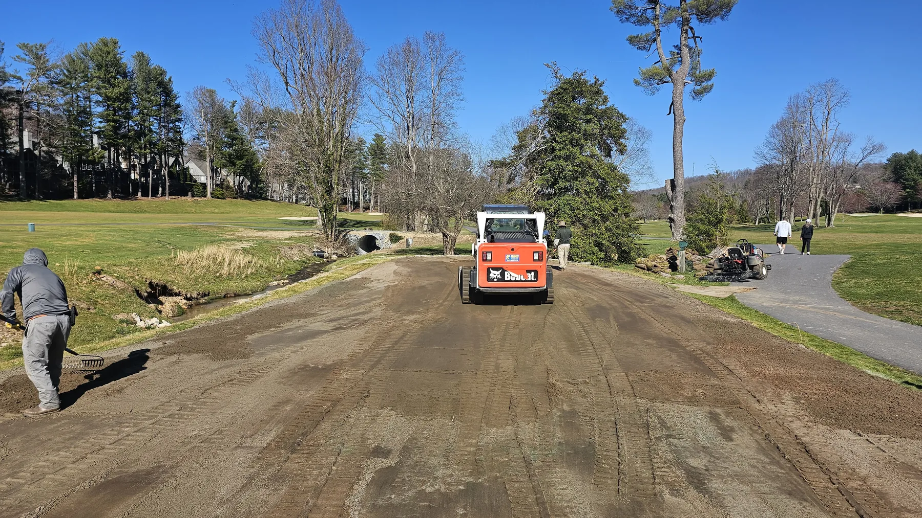 Roller and worker completing renovated tee surface